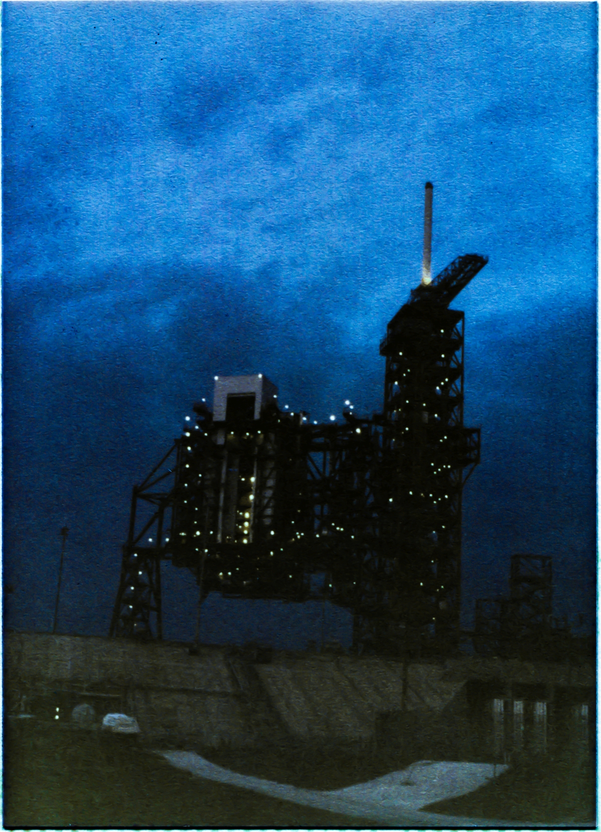 Image 053. At the close of contract NAS10-9655, the body of the Great Rotating Service Structure stands complete, atop the concrete rampart of Space Shuttle Launch Complex 39-B, Kennedy Space Center, Florida. New days and new tasks are crowding in, ever-closer, as preparations continue, aiming for the the first launch from this newly-reborn Pad. The launch of Challenger, in January 1986. Photo by James MacLaren.